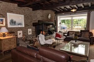 a living room with a leather couch and a fireplace at Bouillon, au faubourg de France, face à la Semois GRAND RAID 26 LES 12 ET 13 SEPTEMBRE 26 in Bouillon +54 photos