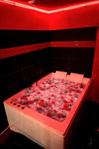 a bath tub filled with flowers in a red room at Lasuitesecretetdetente in Beauvais
