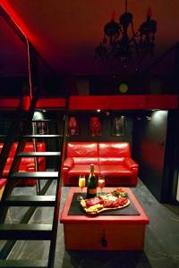 a room with a red couch and a table with a plate of food at Lasuitesecretetdetente in Beauvais +14 photos