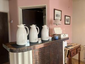 three white vases sitting on a table in a room at Casa Viedma in El Chalten