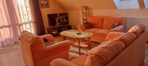 a living room with orange couches and a table at ELEKTRa in Stare Bielice