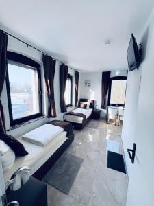 a small room with two beds and a tv at Hotel Royal in Leopoldshöhe