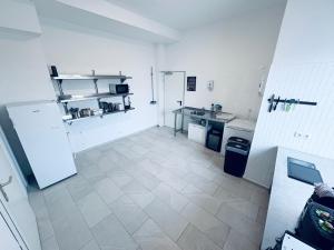 a kitchen with a refrigerator and a tiled floor at Hotel Royal in Leopoldshöhe