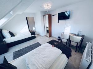 a bedroom with a bed and a desk and a television at Hotel Royal in Leopoldshöhe +58 photos