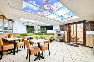 a restaurant with tables and chairs and a skylight at City London Hotel in London