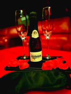 a bottle of wine sitting on a table with two glasses at Lasuitesecretetdetente in Beauvais