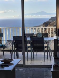 a table and chairs on a balcony with a view of the ocean at Sandra Amadores in Puerto Rico de Gran Canaria