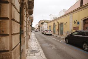 a street with cars parked on the side of a building at Casa Dante in Putignano