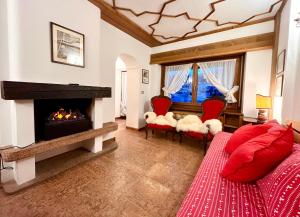 a living room with a fireplace and a red couch at Cortina Relax in Cortina dʼAmpezzo