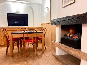 a dining room with a table and a fireplace at Cortina Relax in Cortina dʼAmpezzo