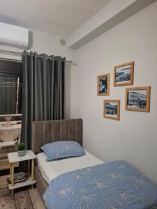 a bedroom with a bed and a table and a window at Panoramic apartment in Shkodër