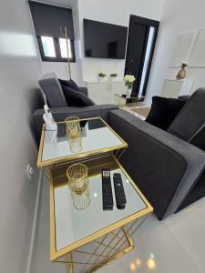 a living room with a couch and two remote controls on a table at Atlantic Dreams II in Pico da Pedra