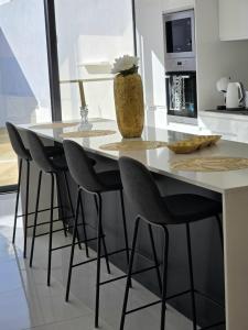 a kitchen with a table with chairs and a vase at Atlantic Dreams II in Pico da Pedra