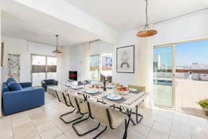 a dining room and living room with a table and chairs at Fig Tree Beach Villa Four in Protaras