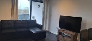 a living room with a couch and a flat screen tv at Modern flat in Abbey Wood in Abbey Wood