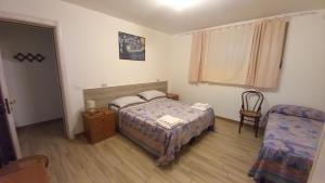 a small bedroom with a bed and a chair at L'Alba della Tavernetta in Locorotondo