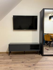 a black entertainment center with a flat screen tv on a wall at Apartman Mia 5 in Liptovský Mikuláš