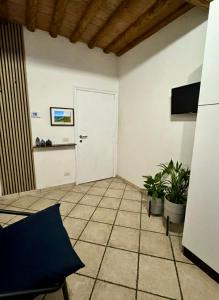 a room with a white door and two plants at A Casa di Diego - Appartamento nel cuore della Toscana in Poggibonsi