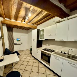 a kitchen with white cabinets and a stove top oven at A Casa di Diego - Appartamento nel cuore della Toscana in Poggibonsi