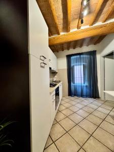 a kitchen with white cabinets and a tile floor at A Casa di Diego - Appartamento nel cuore della Toscana in Poggibonsi +12 photos