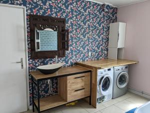 a bathroom with a washing machine and a washer and dryer at Le temps des vacances in Vaudricourt