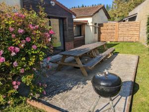 a picnic table and a grill in a yard at Le temps des vacances in Vaudricourt