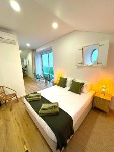 a bedroom with a large white bed with green pillows at Azorescape in Lagoa