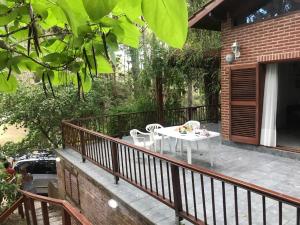 a patio with a table and chairs on a balcony at Casa Encanto in Mar de las Pampas