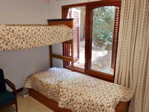 a bedroom with two bunk beds and a window at Casa Encanto in Mar de las Pampas