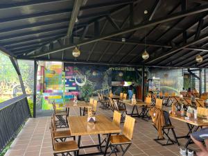 a restaurant with wooden tables and chairs and a mural at Kindia Park Hotel in La Esmeralda