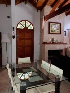 a dining room with a glass table and a fireplace at Casa Encanto in Mar de las Pampas