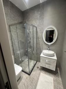 a bathroom with a shower and a sink and a mirror at Villa Mardakan in Mərdəkan +5 photos