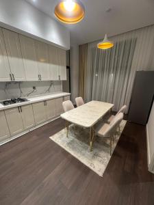 a dining room with a table and chairs and a kitchen at Villa Mardakan in Mərdəkan