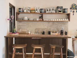 a kitchen with a bar with four stools at Casa Lucia Valladolid in Valladolid +26 photos