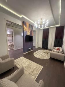 a living room with two couches and a flat screen tv at Villa Mardakan in Mərdəkan