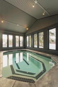 a large indoor swimming pool with windows at Sun & Ski Inn and Suites in Stowe