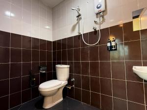 a bathroom with a toilet and a sink at Serene Turtle Hotel in Kuala Terengganu