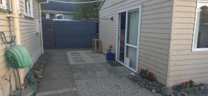 a walkway next to a house with a fence at Cozy corner on Cohen in Nelson