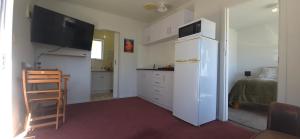 a small kitchen with a white refrigerator and a table at Cozy corner on Cohen in Nelson