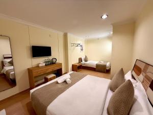 a hotel room with two beds and a television at Serene Turtle Hotel in Kuala Terengganu