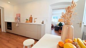 a kitchen with a table with fruits and a vase at Zentrale Wohnung in Garmisch mit Zugspitzblick in Garmisch-Partenkirchen