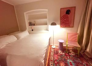 a bedroom with a bed and a lamp and a chair at Zentrale Wohnung in Garmisch mit Zugspitzblick in Garmisch-Partenkirchen