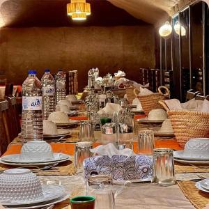a long table with plates and bottles of water at Sand Dunes Luxury Camp in Merzouga
