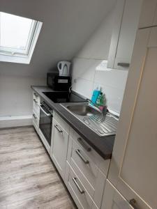 a kitchen with a sink and a stove at Monteurwohnung Krefeld WorkStay in Krefeld
