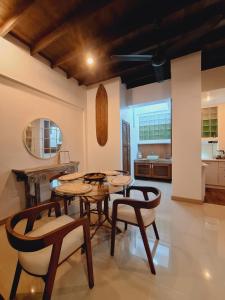 a living room with tables and chairs and a kitchen at The Lighthouse Seaview Hotel in Rawai Beach