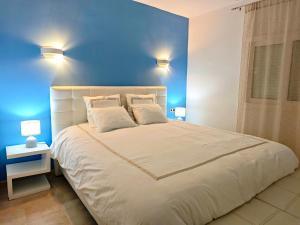a bedroom with a large bed with a blue wall at Canyamel Beach in Canyamel +35 photos