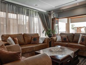a living room with couches and a table at The Orion Guesthouse in Middelburg