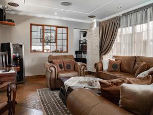 a living room with couches and a table at The Orion Guesthouse in Middelburg