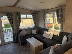 a living room with a couch and a table at Coastal Caravan Seton Sands in Port Seton
