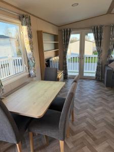 a dining room with a wooden table and chairs at Coastal Caravan Seton Sands in Port Seton